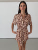 Women wearing leopard print playsuit in front of white wall